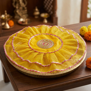 One yellow thaalposh covering a brass pooja thali